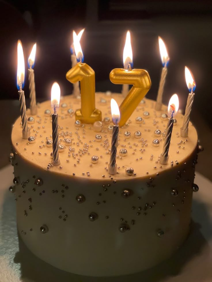 a birthday cake with lit candles and the number twenty seven