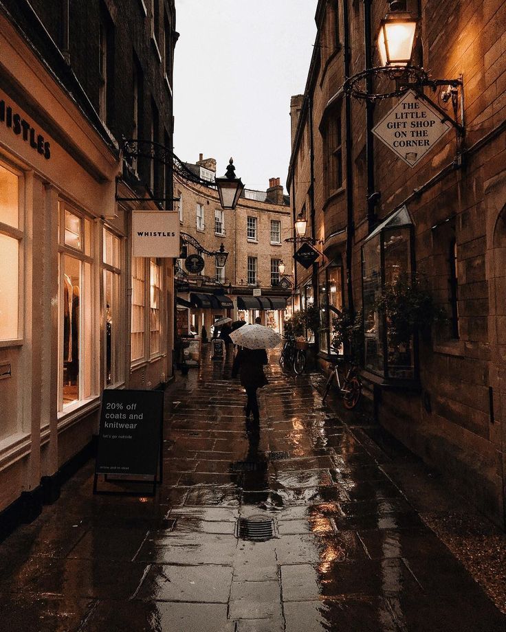 people walking down an alley way holding umbrellas