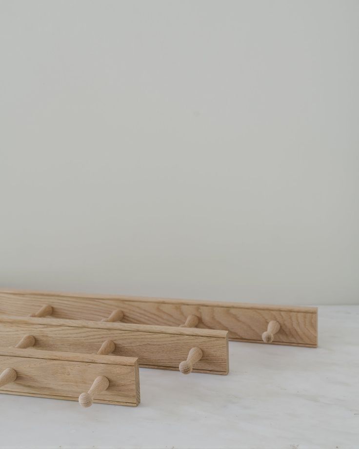 three wooden pegs are lined up against the wall