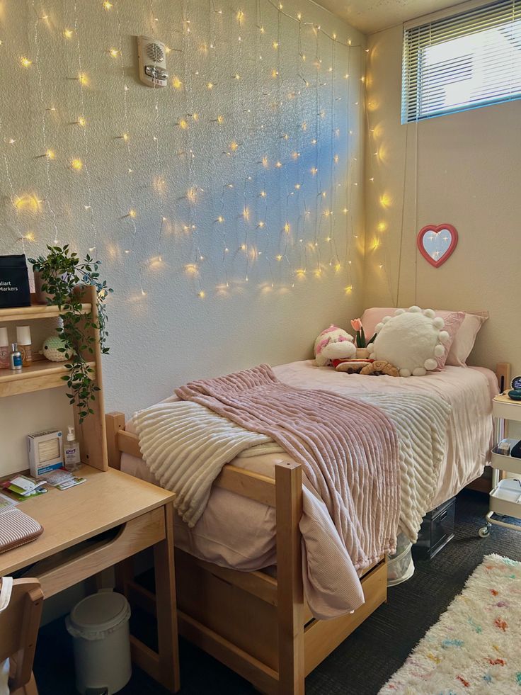 a bed room with a neatly made bed next to a wooden desk and computer monitor