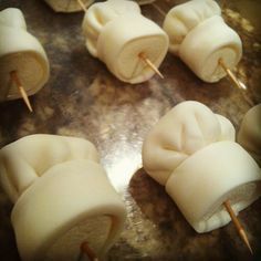 marshmallows with toothpicks stuck in them on a metal surface, ready to be cooked