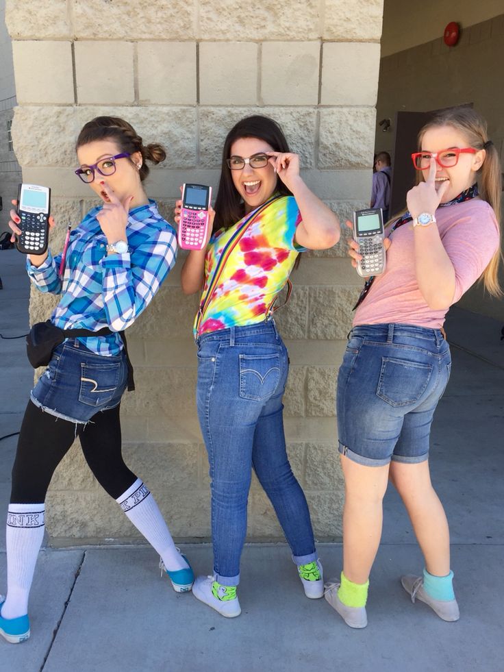 three girls standing next to each other holding cell phones