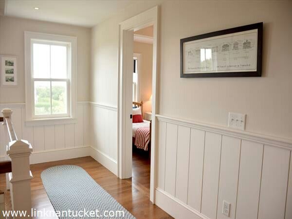 a bedroom with white walls and wood floors