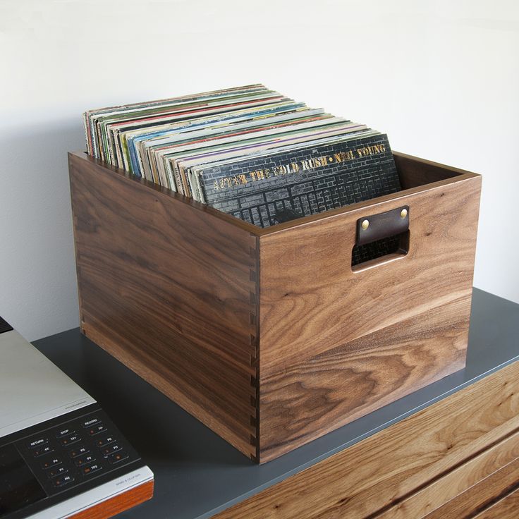 a wooden box filled with records on top of a desk