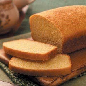 a loaf of bread sitting on top of a cutting board next to a tea pot