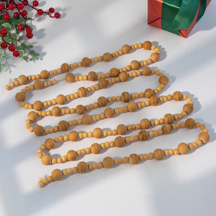 a wooden beaded necklace next to a christmas present