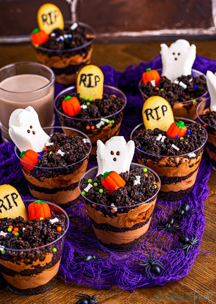 cupcakes decorated to look like halloween desserts on a black tray with chocolate pudding