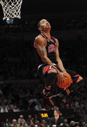 a basketball player jumping up into the air to dunk a ball in front of an audience