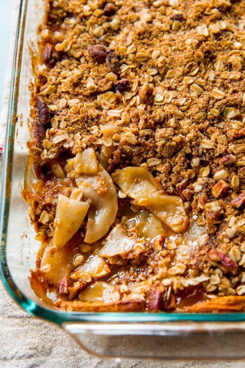 a casserole dish with apples and granola toppings in a glass baking dish