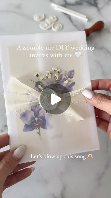 someone holding up a card with flowers on it and the words assemble my diy wedding favors with me