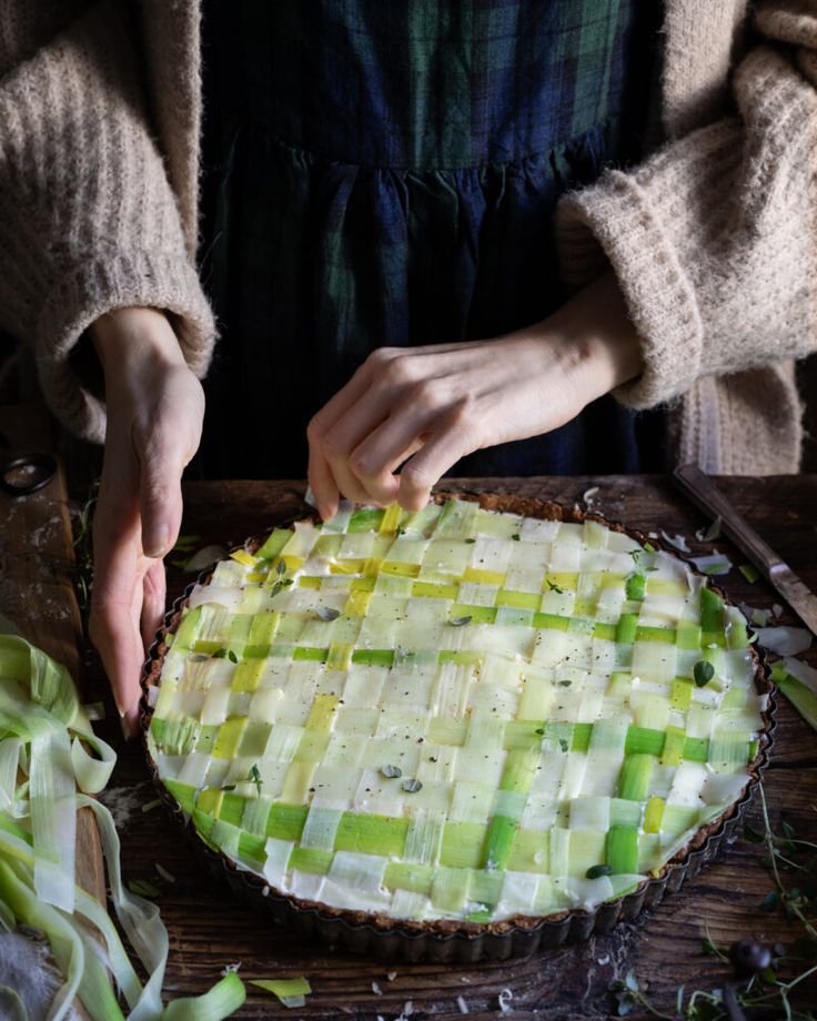 a person cutting up food on top of a wooden table