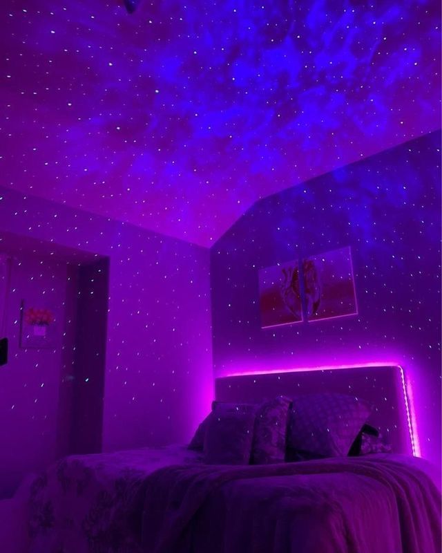 a bedroom with purple lighting and stars on the ceiling