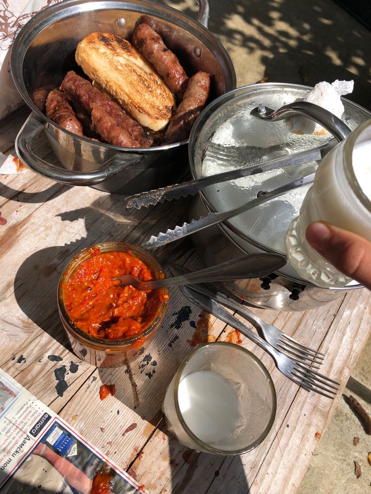 a person is holding a glass with some food in it and there are other dishes on the table