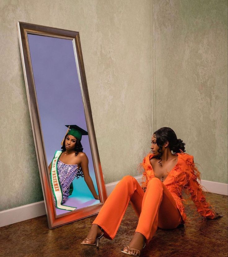 a woman sitting on the floor in front of a mirror with an image of herself