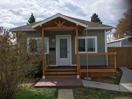 a small house with a porch and wooden steps