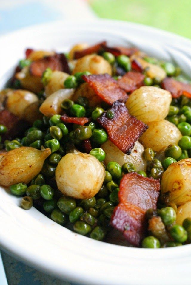 a white bowl filled with peas and bacon