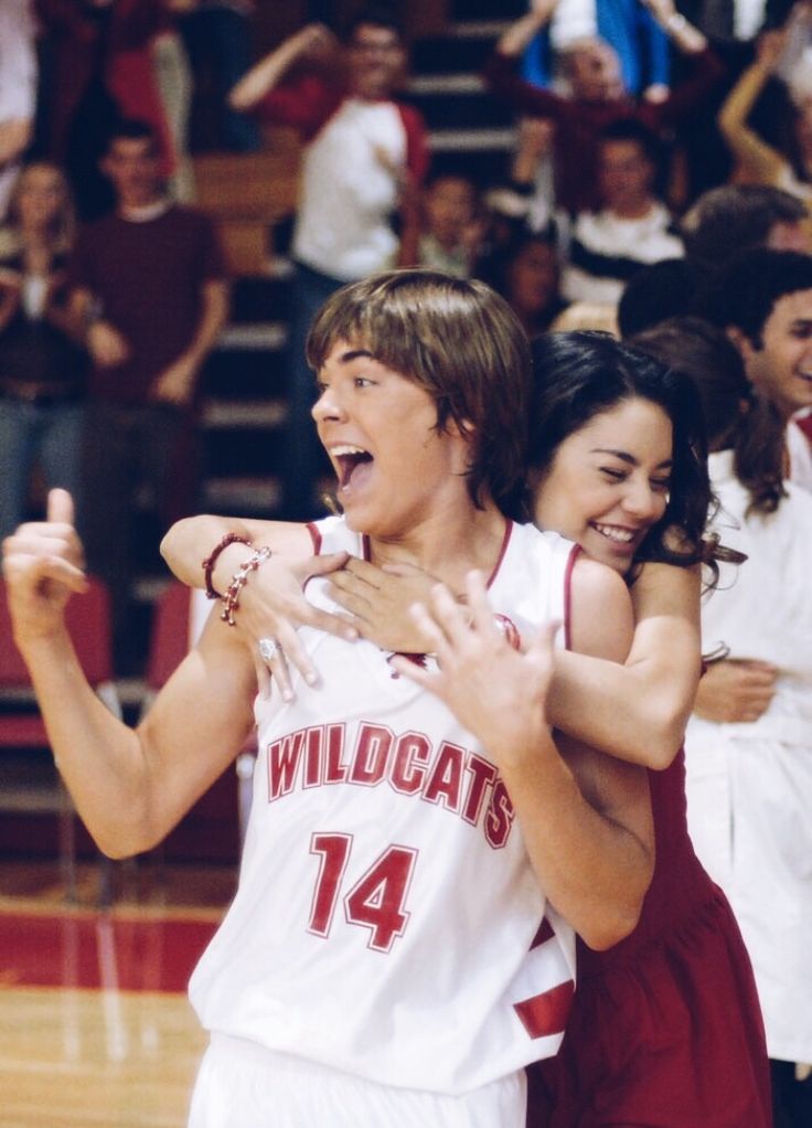 two young people hugging each other on a basketball court