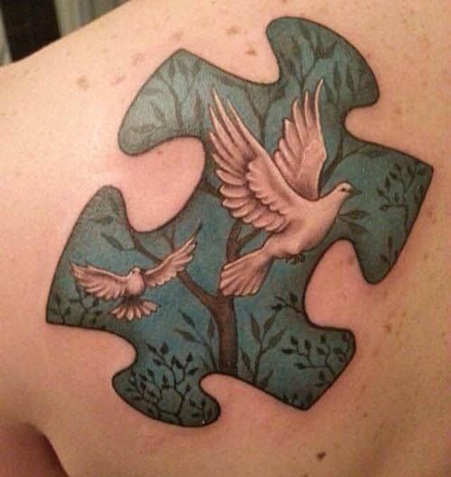 a person with a puzzle piece tattoo on their back and shoulder, holding two doves