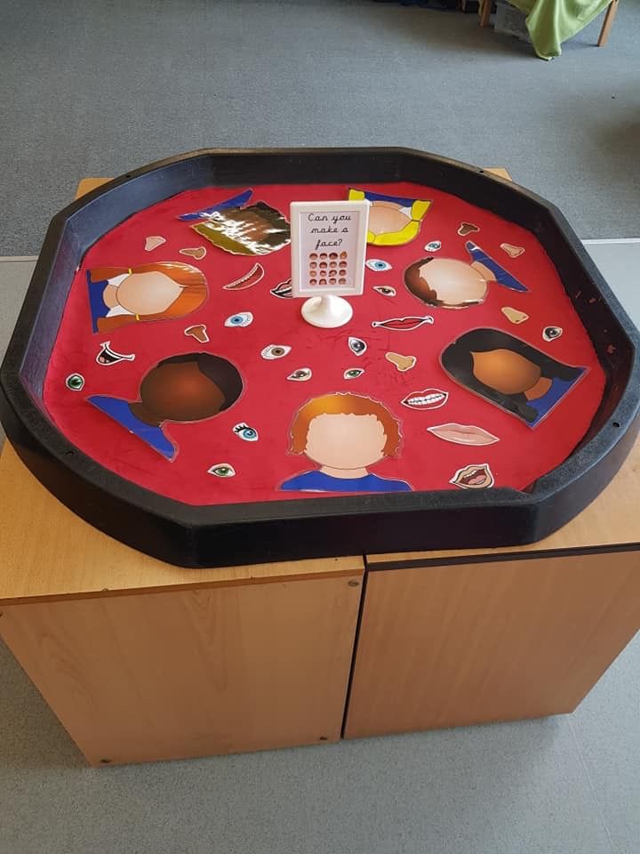 a red tray with pictures on it sitting on top of a wooden cabinet in a room