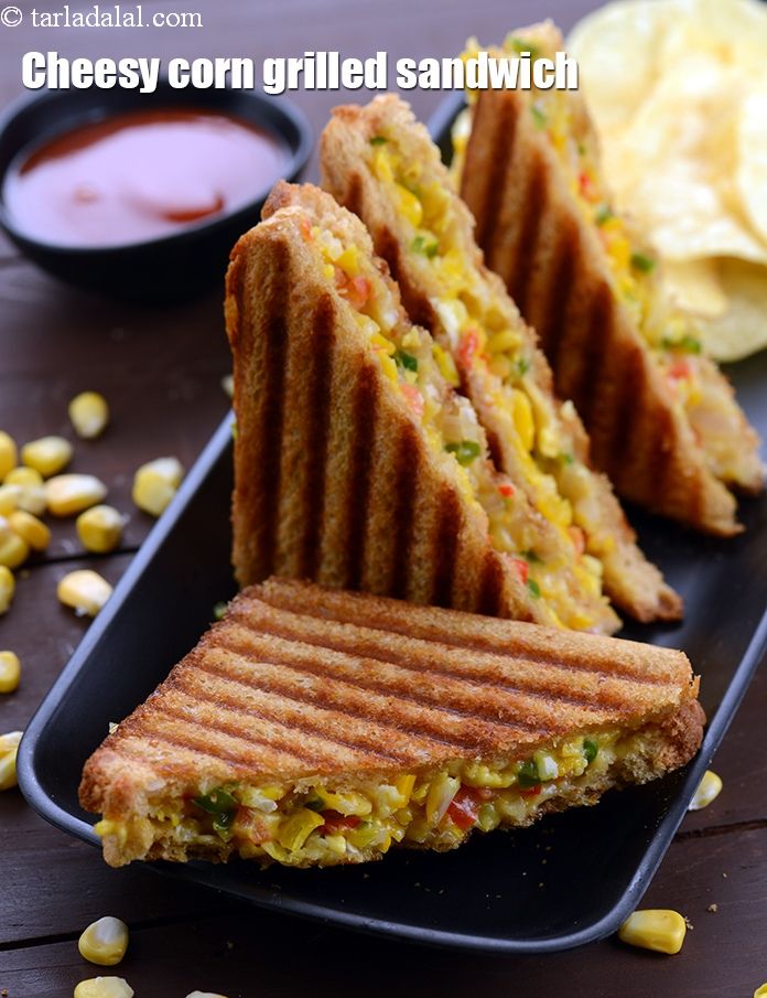 corn grilled sandwich cut in half on a black plate next to chips and dipping sauce