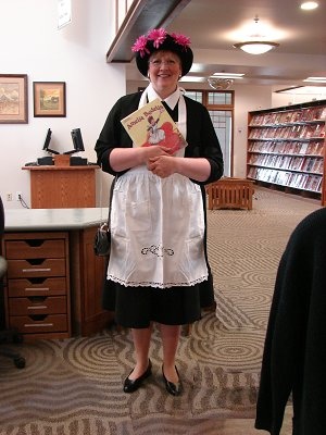 a woman is standing in an office holding a book