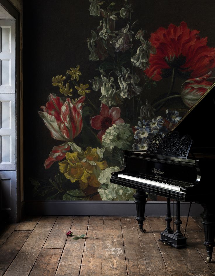 a grand piano sitting in front of a wall with flowers painted on it and an open window