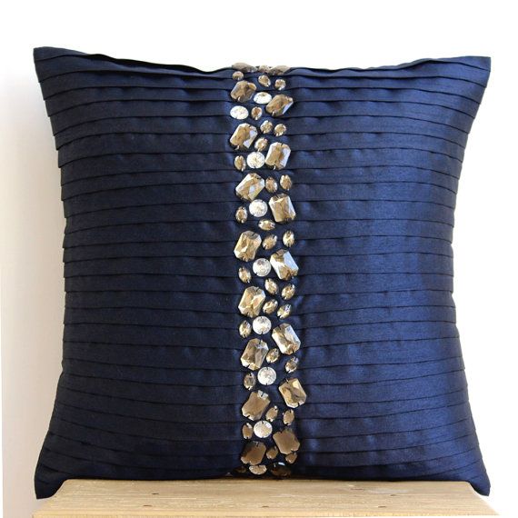 a blue pillow with shells on it sitting on top of a wooden shelf next to a white wall