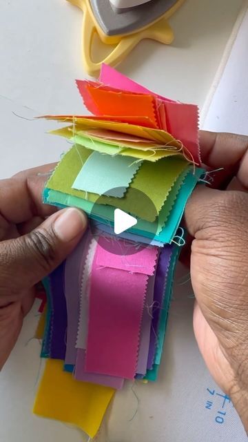 someone is cutting out strips of colored paper