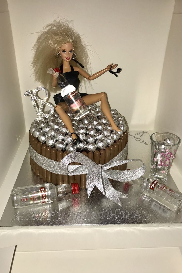 a barbie doll sitting on top of a cake