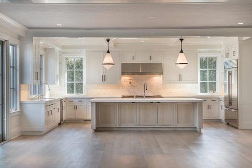 an empty kitchen with white cabinets and wood floors is seen in this image from the inside