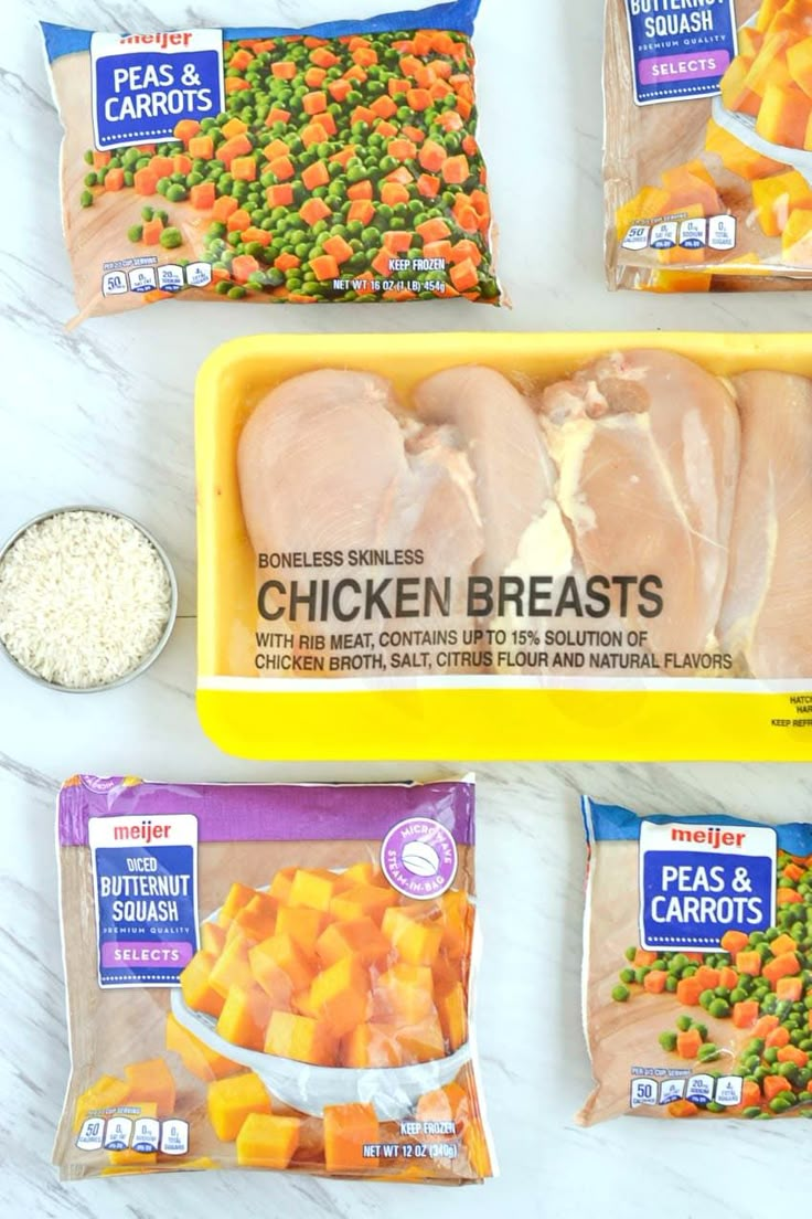 four packages of frozen chicken and carrots on a marble counter top with one bag of peas, the other packaged in plastic