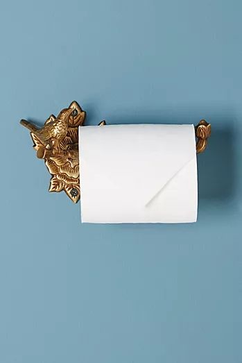 a roll of toilet paper sitting on top of a gold wall mounted towel holder with an elephant head