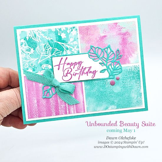 a hand holding up a card with the words happy birthday written in pink, blue and green