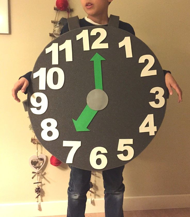 a man holding a large clock with numbers on it