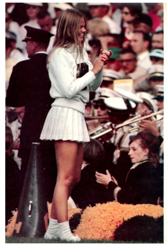 a woman standing on top of a pole in front of a crowd