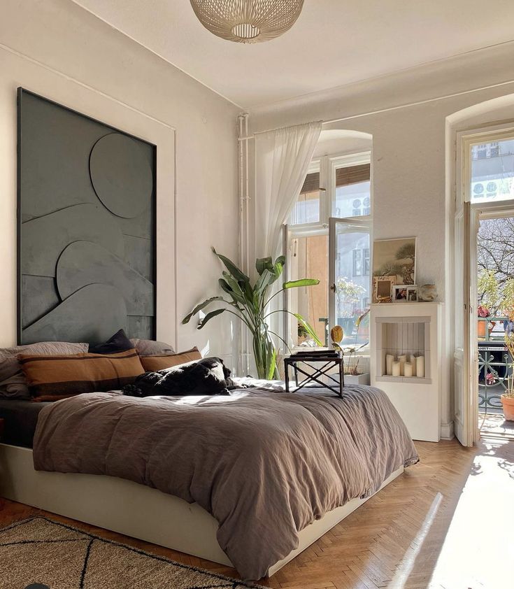 a bedroom with a large bed in the middle and a painting on the wall above it