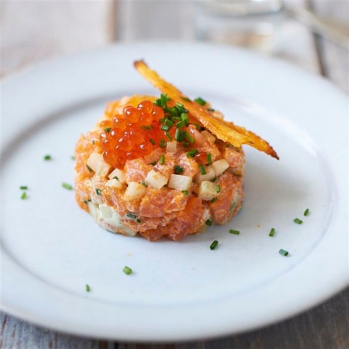 a small appetizer on a white plate with some garnishes in it