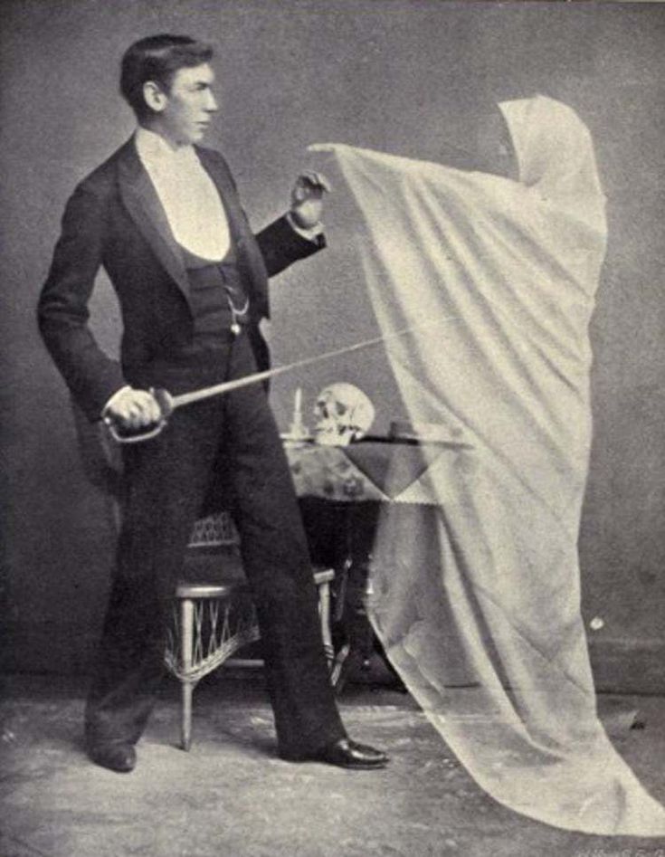 an old photo of a man holding a white cloth in front of a chair with a skeleton on it