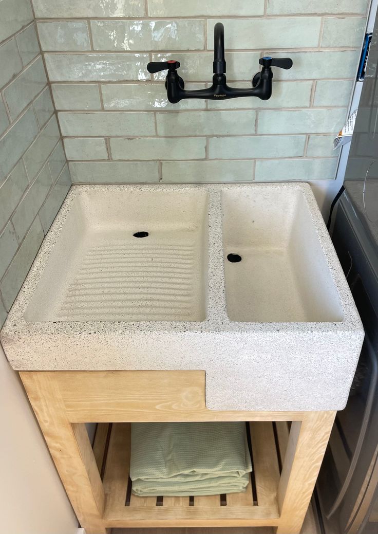 two white sinks sitting under a faucet in a bathroom