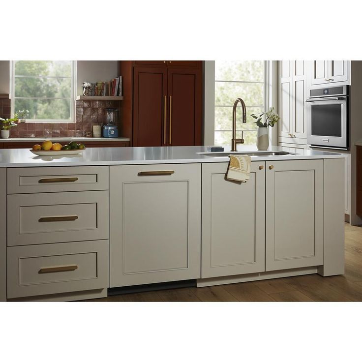 a kitchen with white cabinets and wooden floors