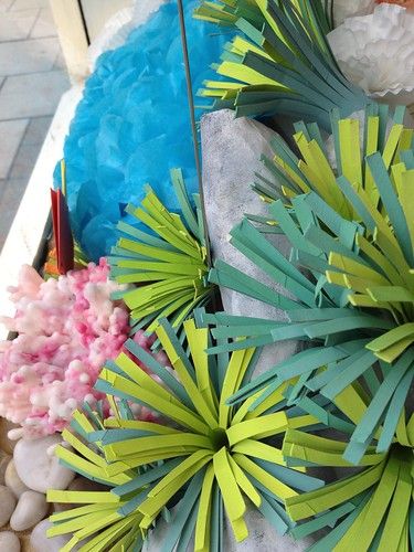 some paper flowers are laying on the ground next to rocks and pebbles in front of a building