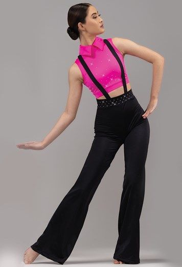 a woman in pink shirt and black pants standing on one leg with her hands behind her back