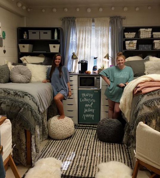 two people sitting on top of beds in a room with lots of pillows and blankets