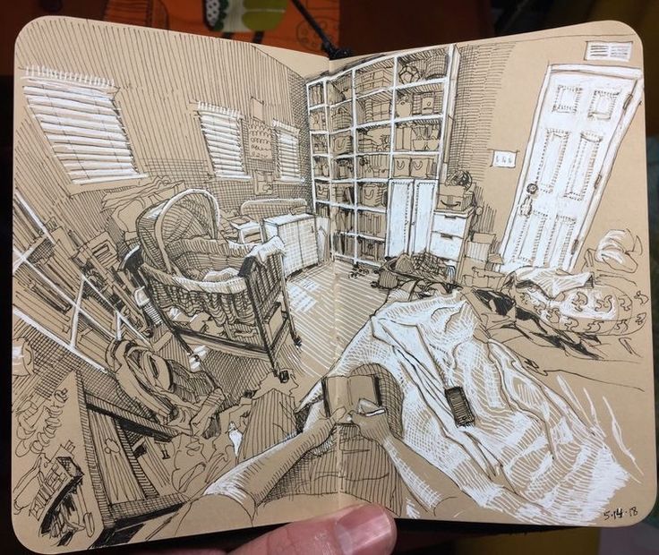 a hand holding up a drawing of a room with bookshelves and other items