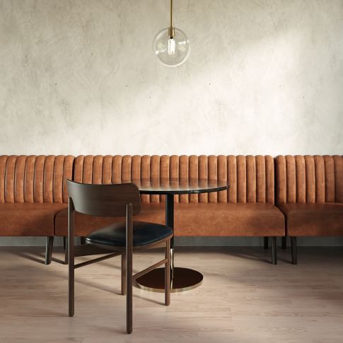 a table with two chairs and a bench in front of a wall that has a light bulb hanging above it