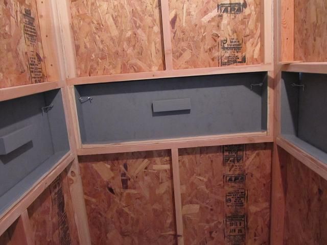 the inside of a bathroom with wooden walls and plywood panels on the wall,