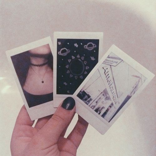 three polaroid photos are held in the palm of a person's left hand