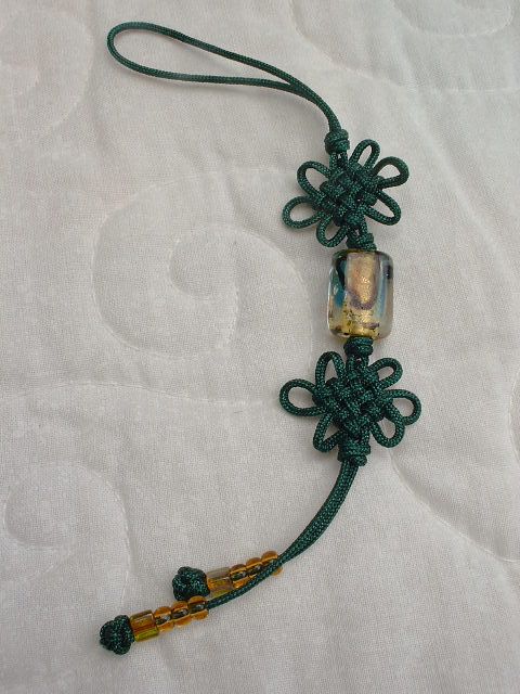 a green string with beads on it laying on a white sheet