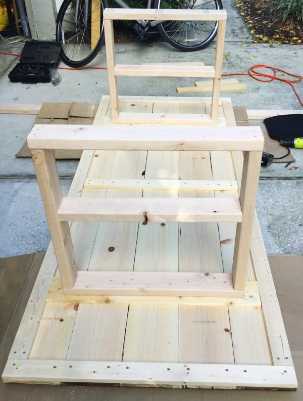 a wooden shelf sitting on top of a table next to a bike parked in the background