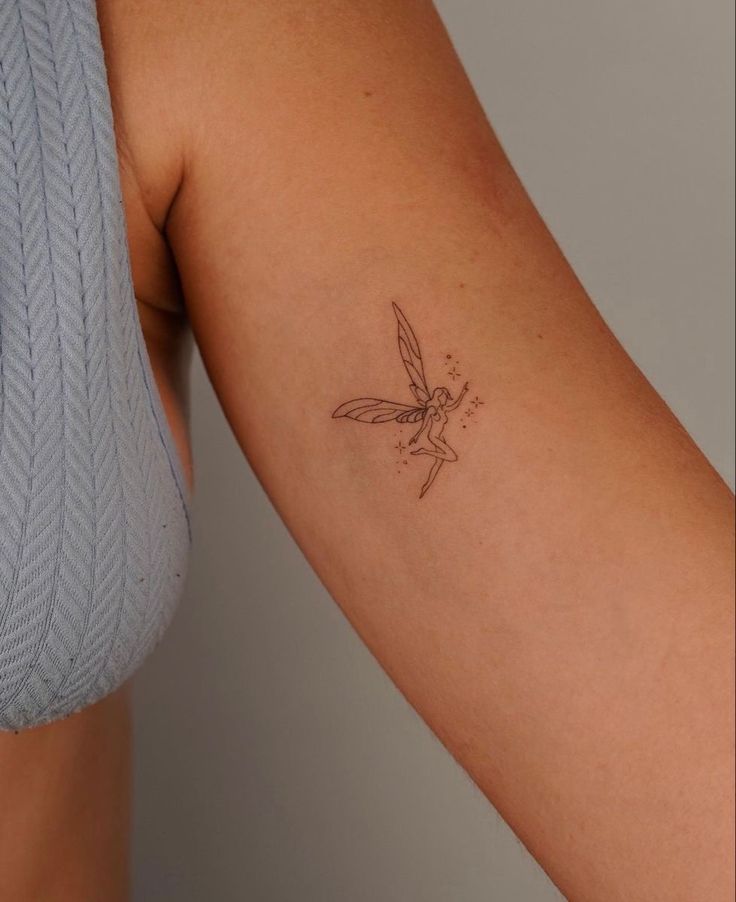 a woman's arm with a small tattoo design on the left side of her arm